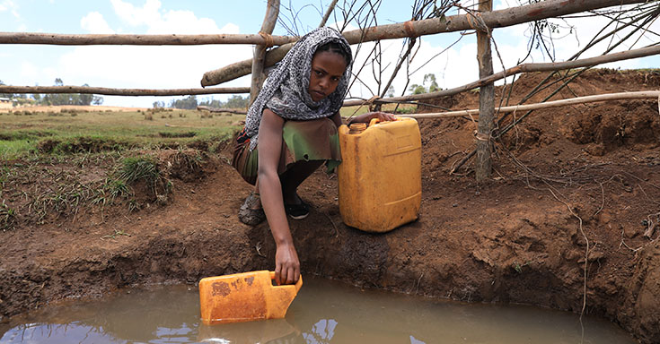 Mädchen holt Wasser bei in einer Wasserstelle (Foto)